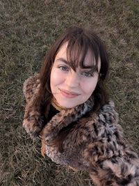 a woman in a fur coat is taking a selfie